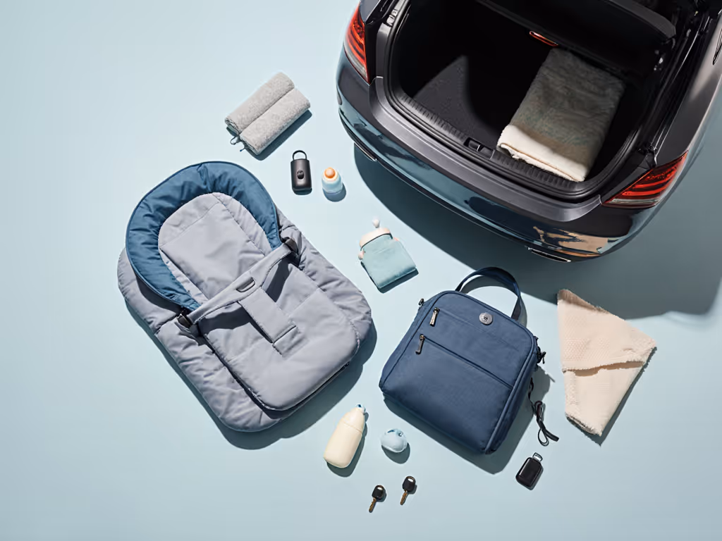 compact_baby_bouncer_folded_next_to_a_small_car_trunk